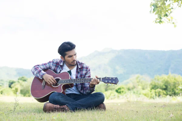 Young hipster man practiced guitar in the park,happy and enjoy p — Stock Photo, Image