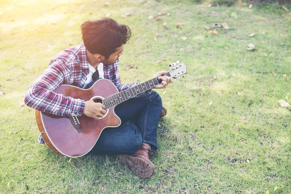 Young hipster man practiced guitar in the park,happy and enjoy p — Stock Photo, Image