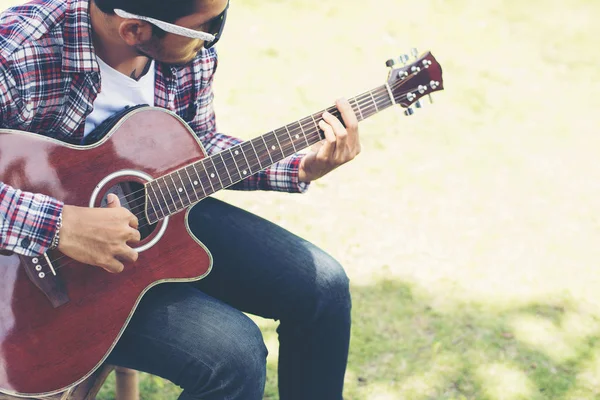 Portrait of young hipster man practiced guitar in the park,happy — Stock Photo, Image