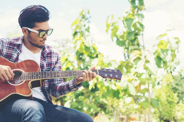 Portrait of young hipster man practiced guitar in the park,happy — Stock Photo, Image