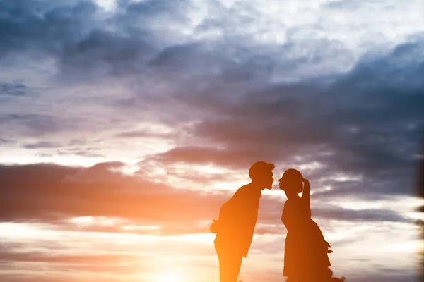 Tatlı çift günbatımı arka plan üzerinde öpüşme silüeti. — Stok fotoğraf