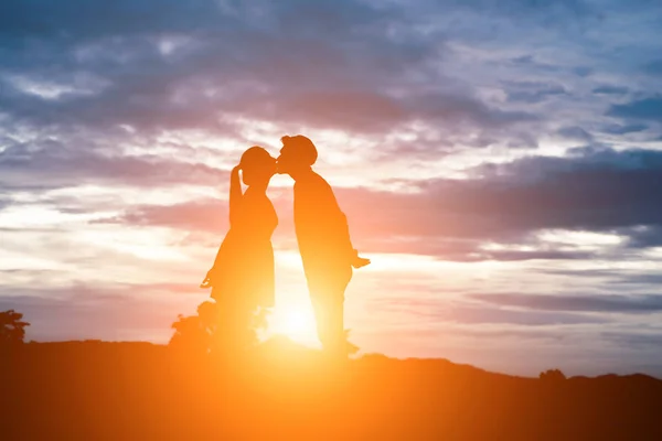 Silhuetten av söta par kyssar över solnedgången bakgrund. — Stockfoto