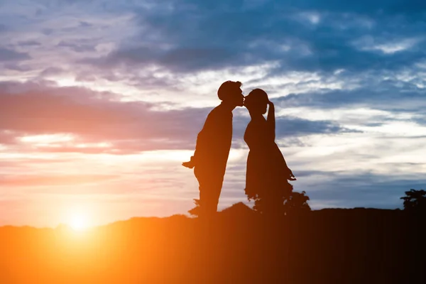 Silhueta de casal doce beijando sobre o pôr do sol fundo . — Fotografia de Stock