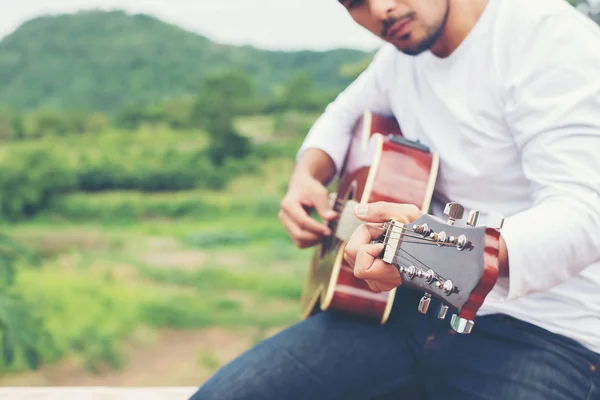 Young hipster man playing guitar to relaxing on his holiday, enj — Stock Photo, Image