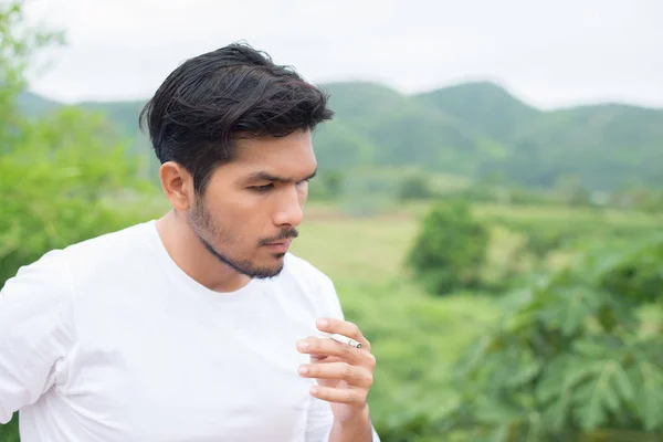 Young hipster man taking rest, smoking cigarette with nature and — Stock Photo, Image