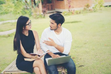 Bankta oturan genç eğitim çift çalışma hakkında konuşmak 