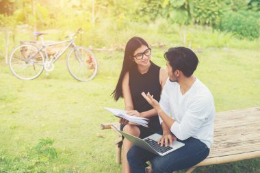 Bankta oturan genç eğitim çift çalışma hakkında konuşmak 