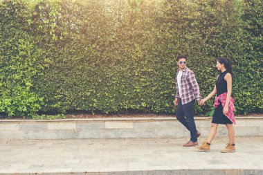 Genç hippi çift içinde kentsel yürüyüş elele.