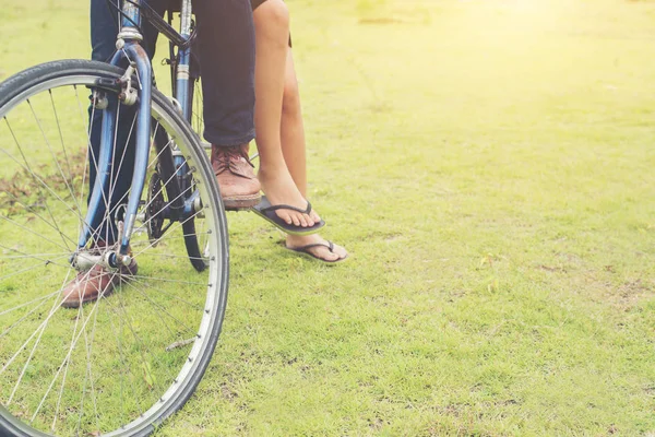 Las piernas de la joven pareja sentada en bicicletas relajante listo para r — Foto de Stock