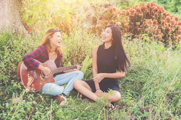 Mladí dospívající při hraní na kytaru při pohledu na její přítelkyni, — Stock fotografie