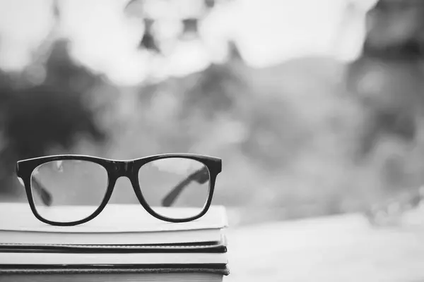 Book and eye glasses for read and write over blurred nature outd — Stock Photo, Image