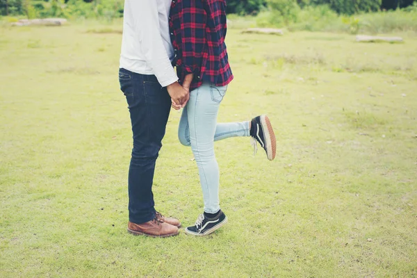 Pies de tu joven pareja besándose en el parque. Pareja enamorada . — Foto de Stock