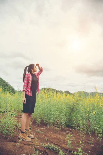 Jovem feliz desfrutando de verão no campo de flores amarelas no natu — Fotografia de Stock
