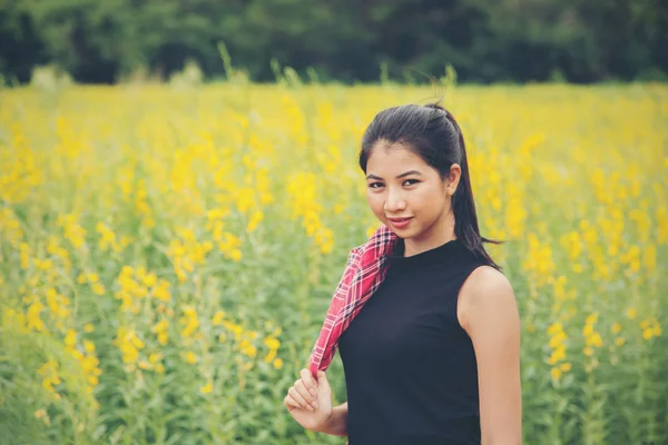 Glückliche junge schöne Frau genießt den Sommer in gelben Blume fie — Stockfoto
