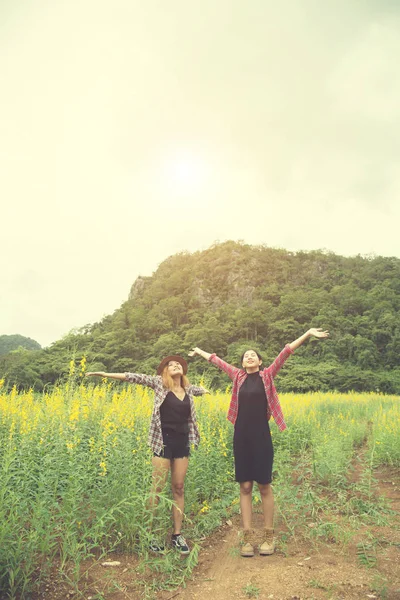 Dos mujeres hipster viajando y levantando las manos disfrutando con flujo — Foto de Stock