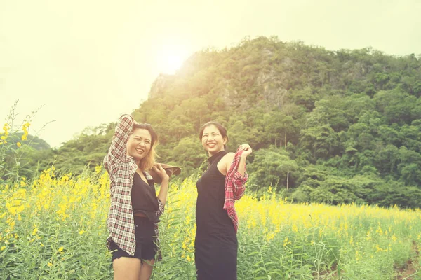 Duas hipster mulher viajando e desfrutando com toget campo de flores — Fotografia de Stock