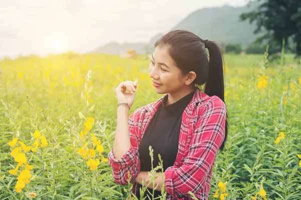 Happy young beautiful woman enjoying summer in yellow flower fie — Stock Photo, Image