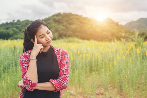 Denken vrouw stond op het gebied van de bloem. — Stockfoto