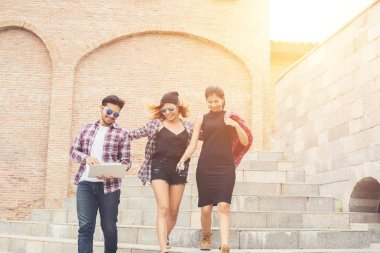 Grup mutlu hipster genç öğrenci merdivenlerden aşağı yürüyüş 