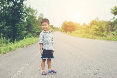 Sokak ve bir fre ile kameraya gülümseyen çocuk durdu