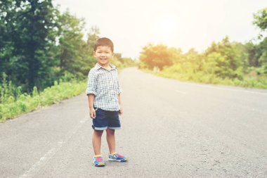 Sokak ve bir fre ile kameraya gülümseyen çocuk durdu