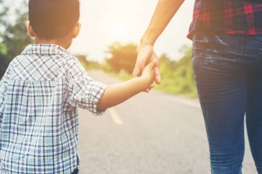 Yaz günü st üzerinde yürüyen bir el oğlu tutan anne