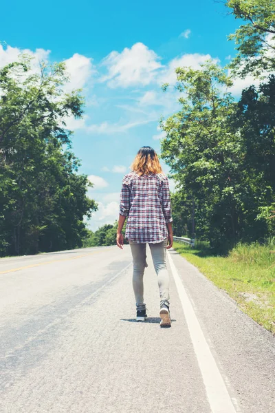Joven hipster mujer caminando lejos en el camino lateral solo . — Foto de Stock