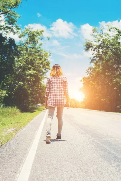 Joven hipster mujer caminando lejos en el camino lateral solo . — Foto de Stock