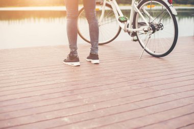 Ahşap köprü, bisikletle yakın duran kadın ayakları dinlenirken ücretsiz
