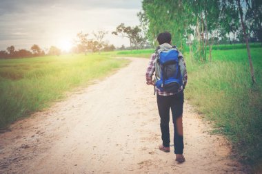 Genç hipster adam yürüme onun omuz sırt çantası ile kapatmak