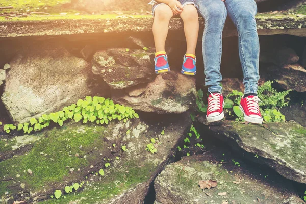 Annem ve onun küçük oğlu feets cliffside oturma. — Stok fotoğraf