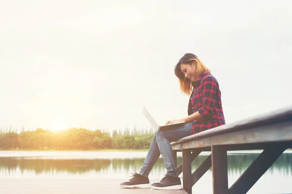 Jovem feliz hipster mulher trabalhando com seu laptop sentado na torta — Fotografia de Stock