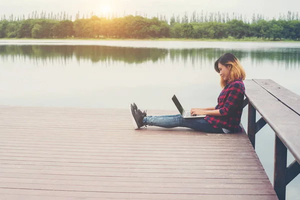 Kobieta młody szczęśliwy hipster pracę z jej laptopie siedząc na ciasto — Zdjęcie stockowe