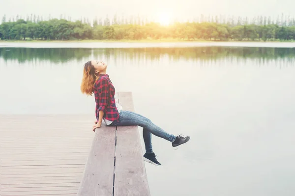 Jovem hipster mulher sentada no cais de madeira, relaxante deitado perna d — Fotografia de Stock