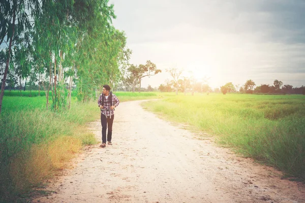Genç hipster adam cou yürüyüş onun omuz sırt çantası ile