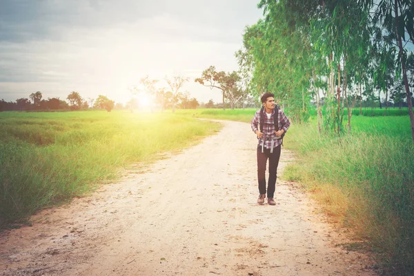 Genç hipster adam cou yürüyüş onun omuz sırt çantası ile