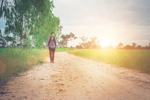 Joven hipster hombre con mochila en su hombro caminando por cou — Foto de Stock