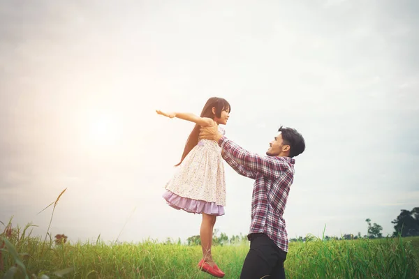 Papa uitvoering van zijn dochter met natuur en zonlicht, plezier — Stockfoto