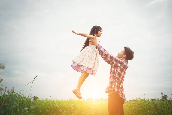 Tatínek, nesoucí svou dceru s přírodou a sluneční světlo, radost — Stock fotografie