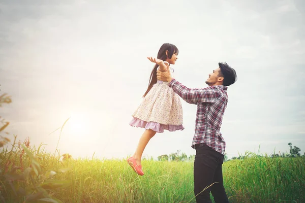 Doğa ve güneş ışığı, keyfi kızıyla taşıyan baba — Stok fotoğraf