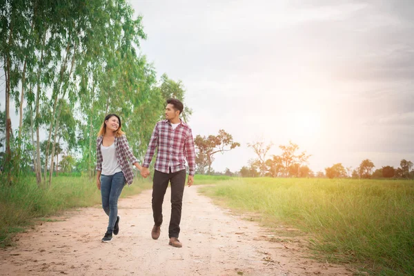 Joven pareja hipster caminando por el camino rural disfrutando con la naturaleza , —  Fotos de Stock