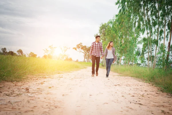 Hipster νεαρό ζευγάρι περπάτημα σε αγροτικό δρόμο, απολαμβάνοντας με τη φύση, — Φωτογραφία Αρχείου