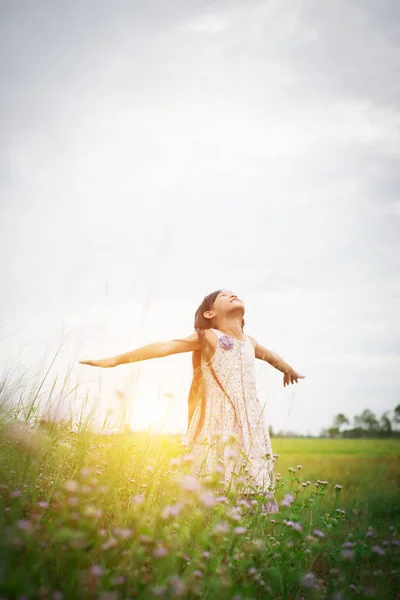 Little cute asian girl standing among the purple flower field su — Stock Photo, Image