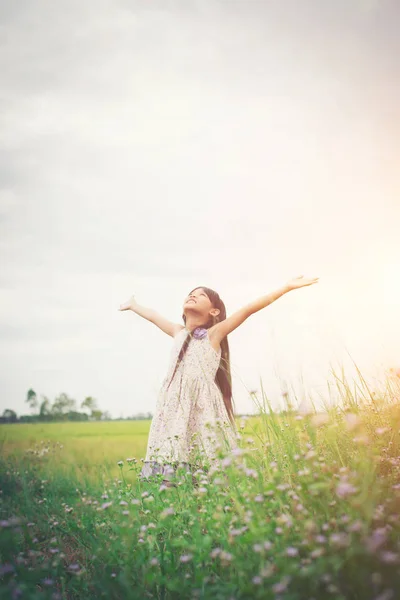 Pouco bonito asiático menina de pé entre o roxo flor campo su — Fotografia de Stock