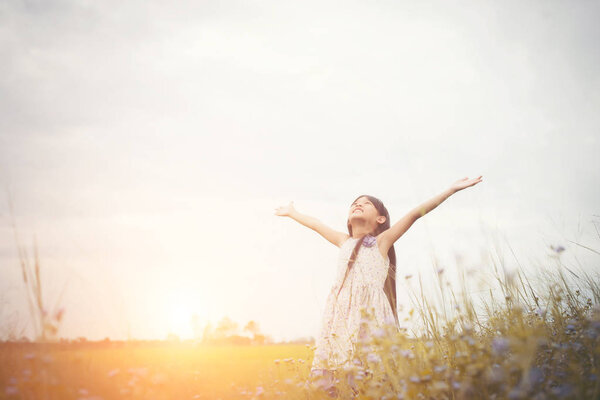 Little cute asian girl standing among the purple flower field su