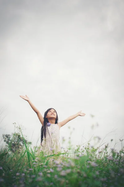 Little cute asian girl standing among the purple flower field su — Stock Photo, Image