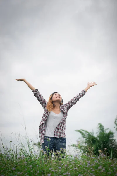 Jovem mulher hipster bonita em um campo de flores ao pôr do sol. Libertado. — Fotografia de Stock