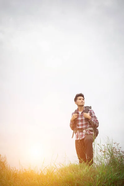 Retrato de joven hipster hombre al aire libre levantando las manos con backpac — Foto de Stock