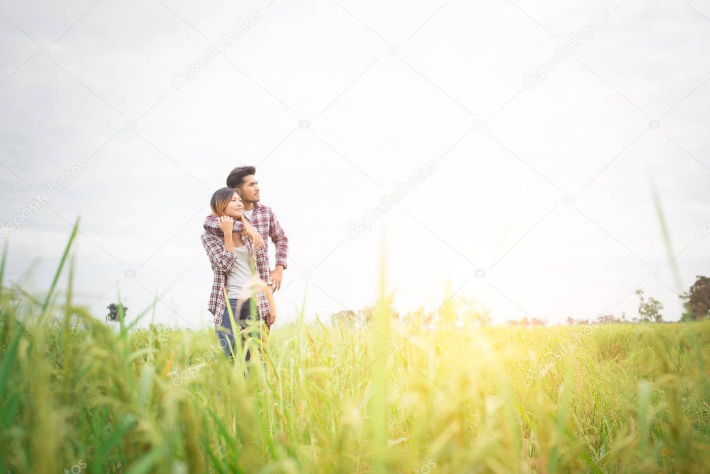 Young hipster couple standing on field pointing look away to the