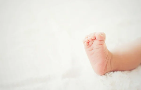 Novorozence Baby nohy na bílé posteli. — Stock fotografie